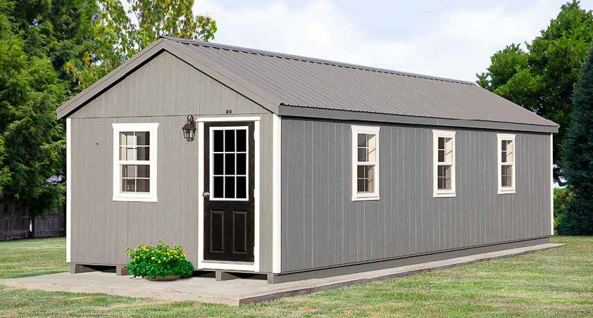 12x32 commercial kennel with gray siding, gray roofing, white trim, a black door, and windows.