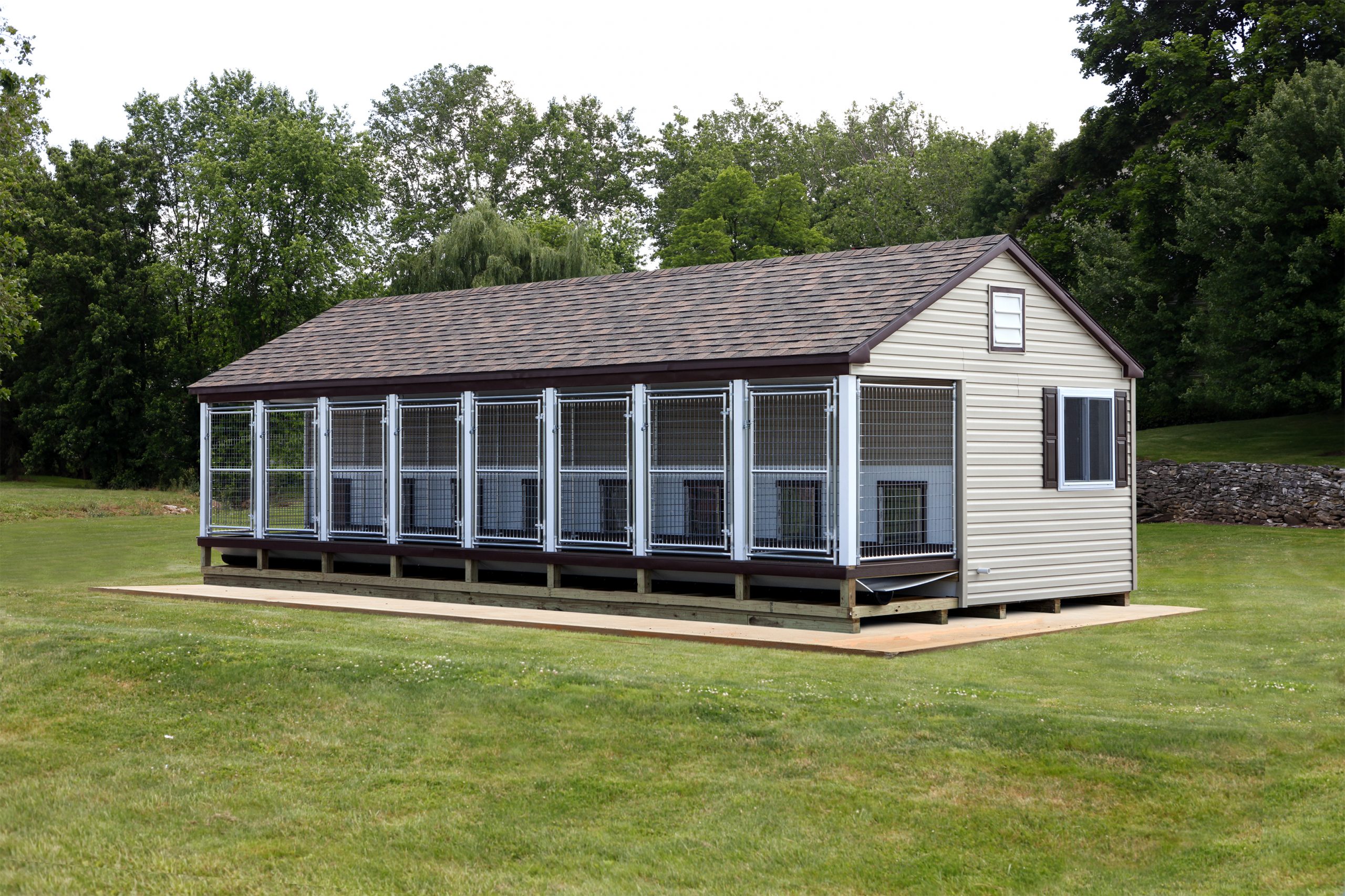 14x32 commercial kennel with 8 dog runs, tan siding, brown roofing, and white trim.