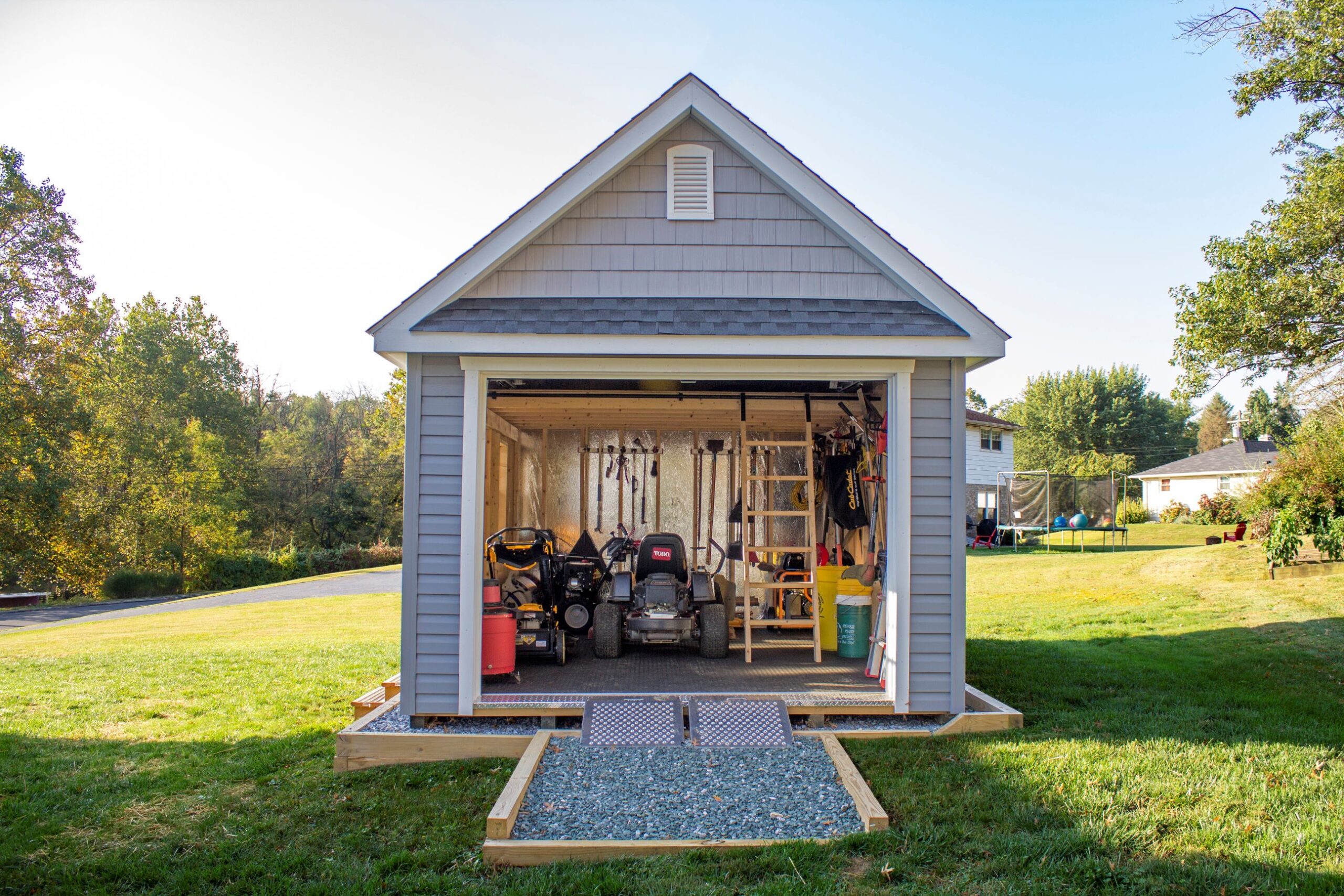 Front view of a New England Barn Shed with an open door that shows inside the interior.