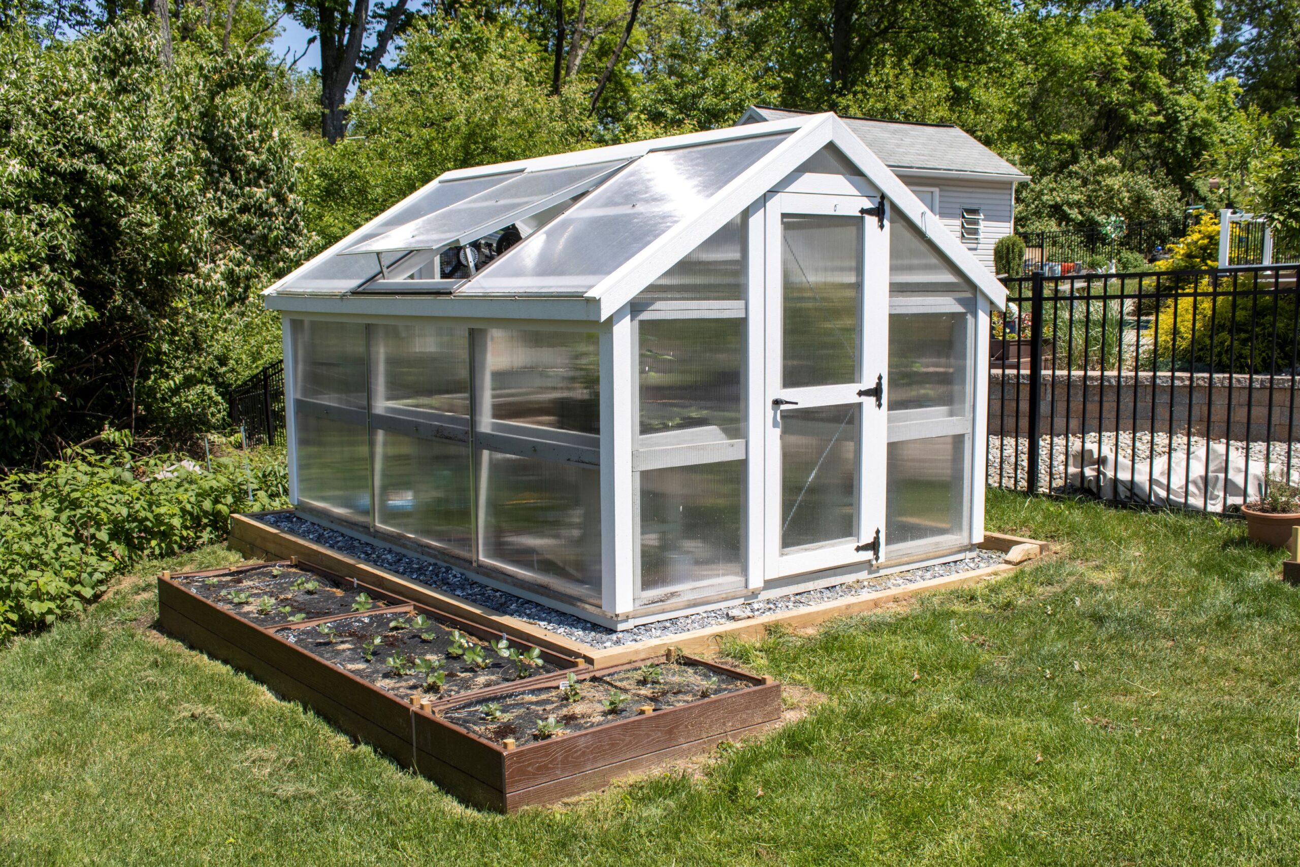 Left side view of a white A-Frame Greenhouse with planter boxes along the side.