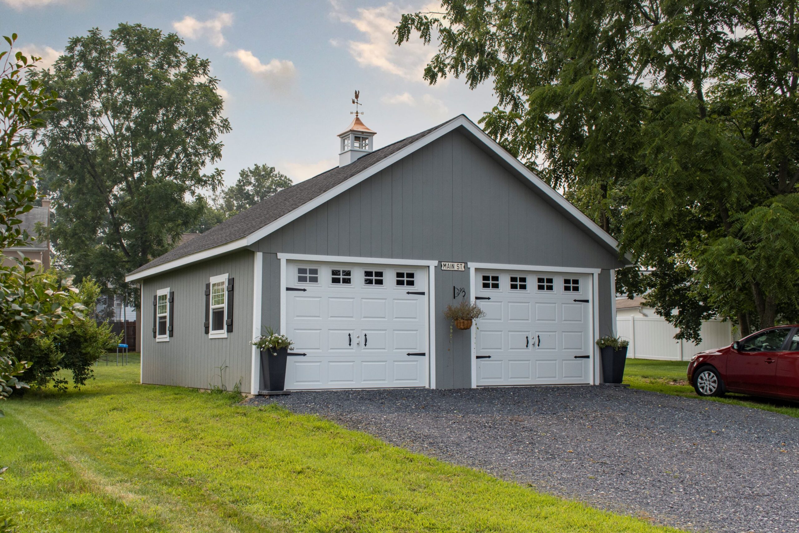 Front exterior of a 2-car, 2-story Lexington Garage with gray siding and white garage doors.