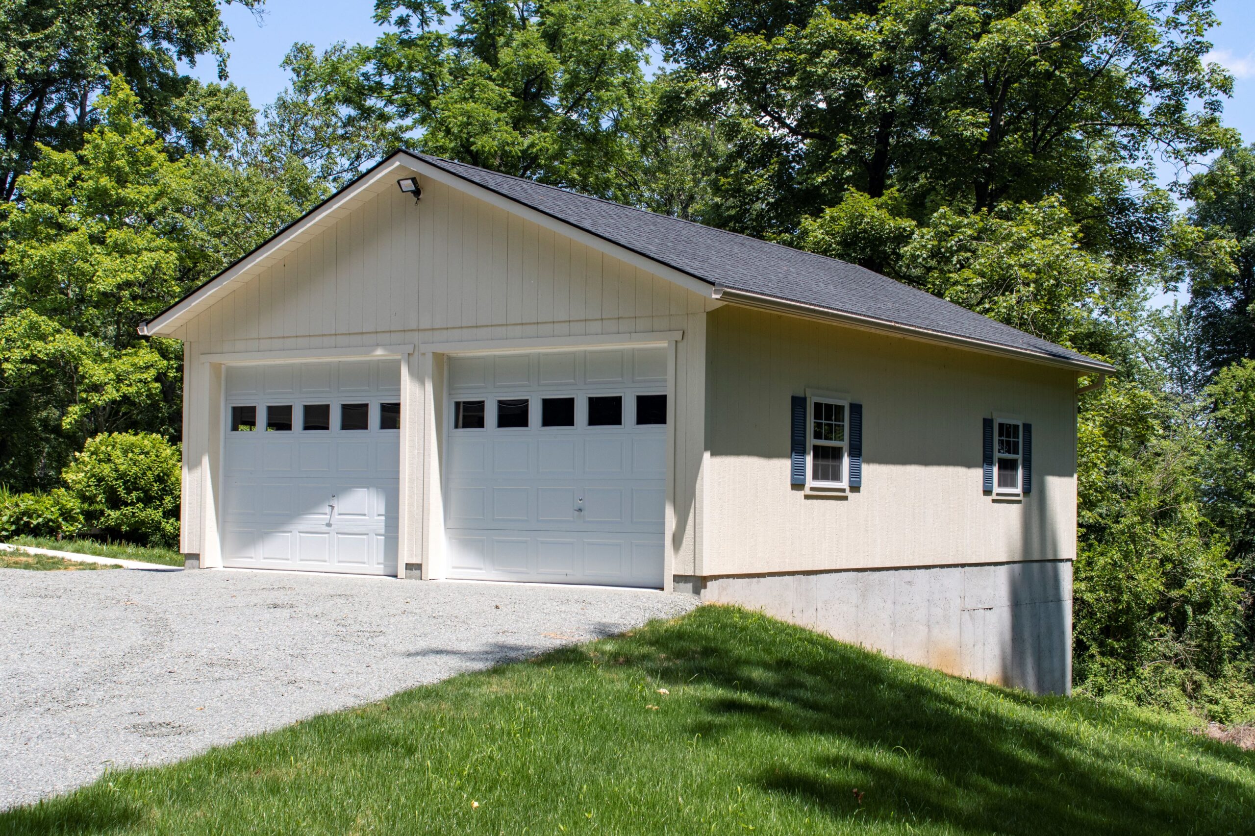 Exterior of a 1-story 2-car Richmond Garage with beige siding and 2 white garage doors.