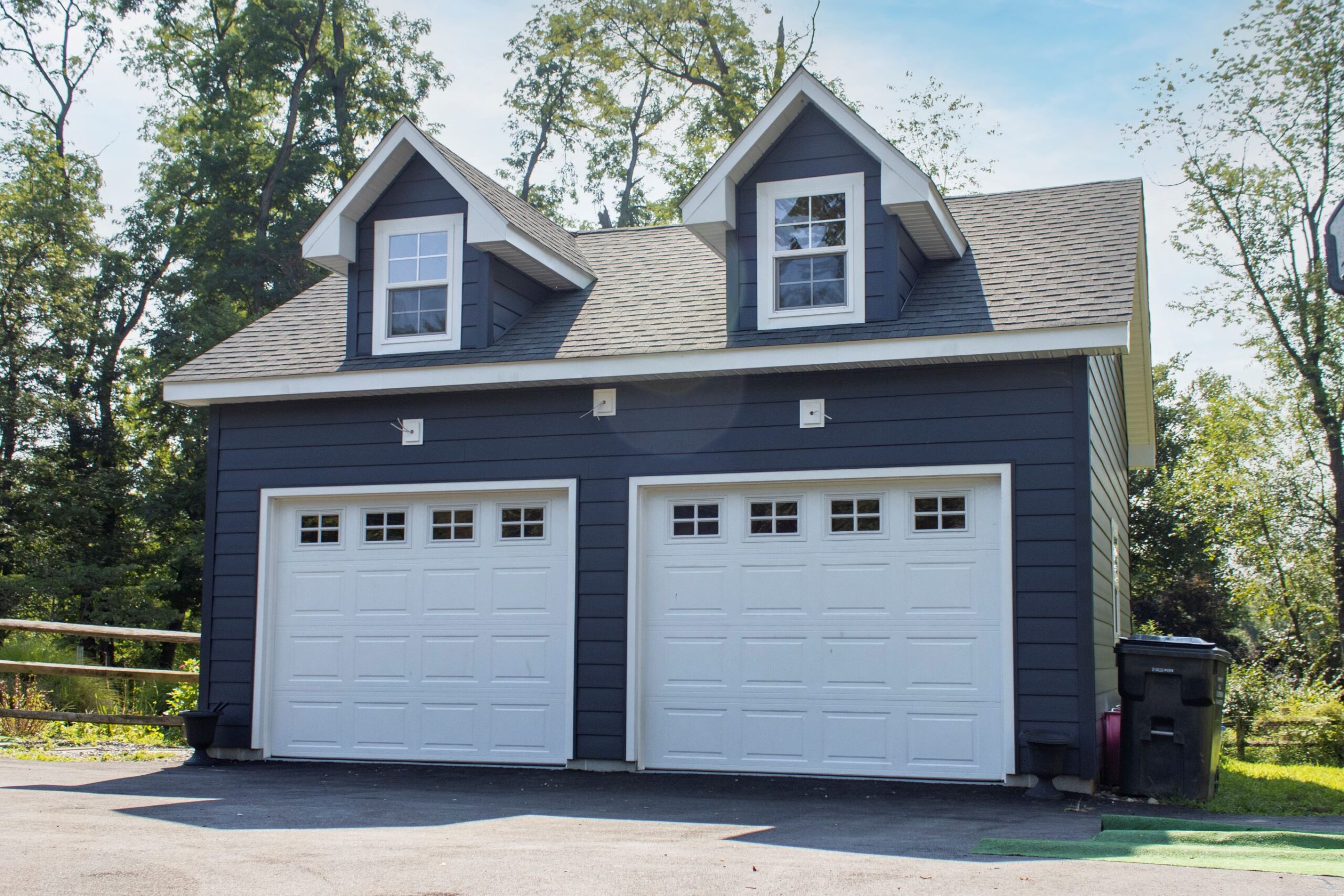Exterior of a 2-story, 2-car Garden Shed Garage with blue siding and white garage doors.