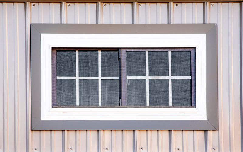 Close up of a white and gray 20x40 double-pane window on a dog kennel