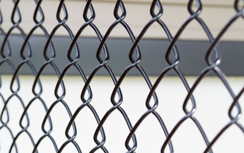 Close up of a black-coated chain-link fence