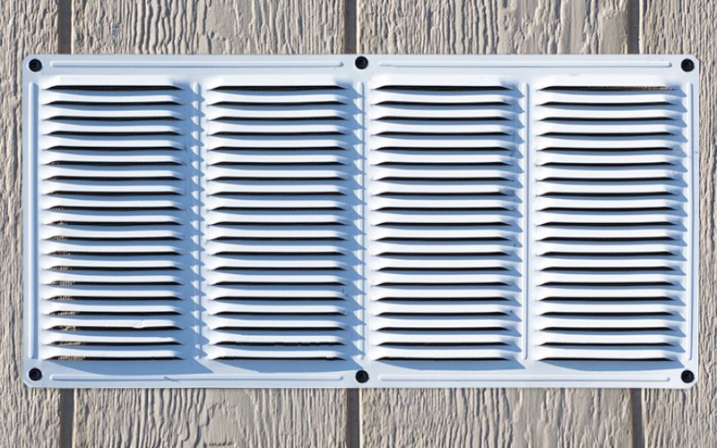 Close up of a white metal gable vent