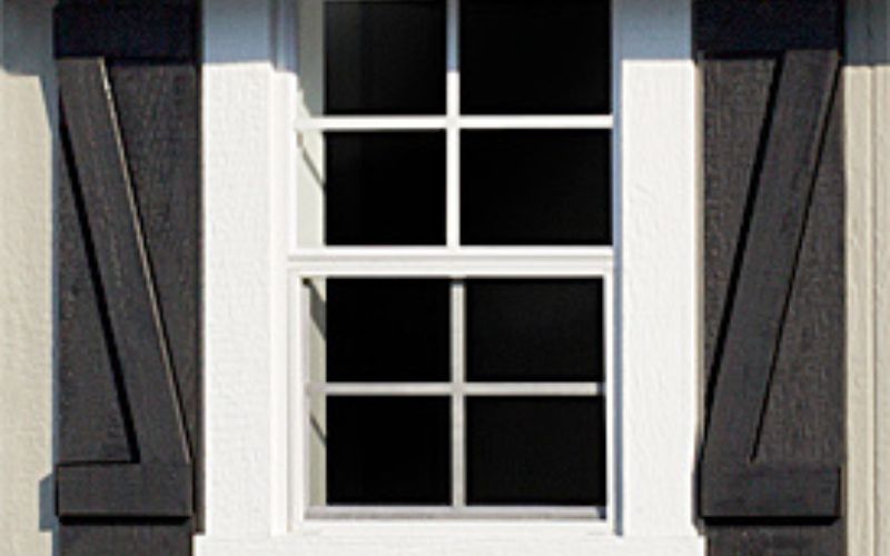 Close up of a white window with black Z shutters