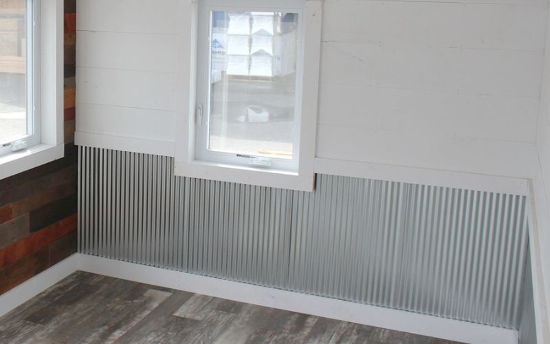 Shed interior with corrugated metal wainscoting and white walls