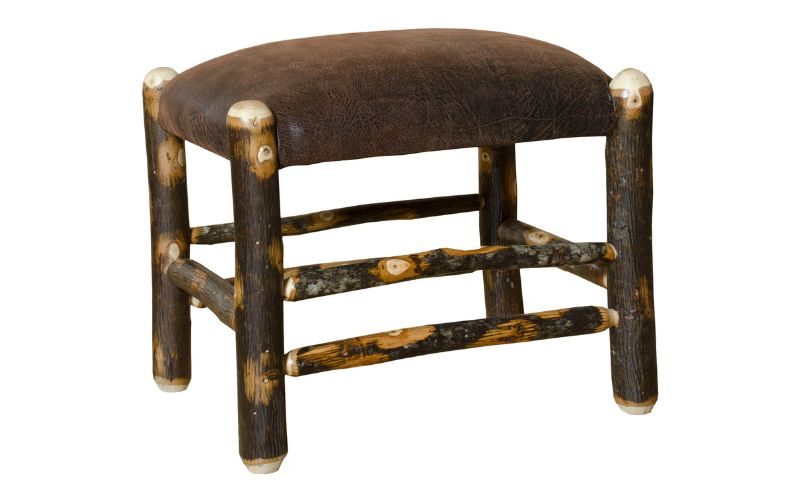 Footstool with brown leather cushion and a dark branch base
