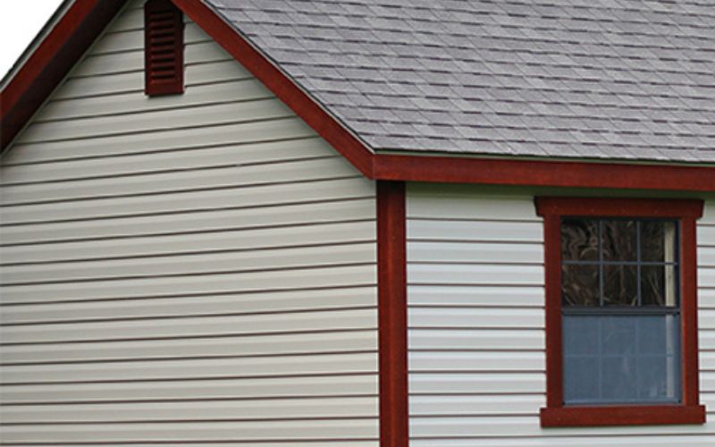Close up of red MiraTec trim on a white shed