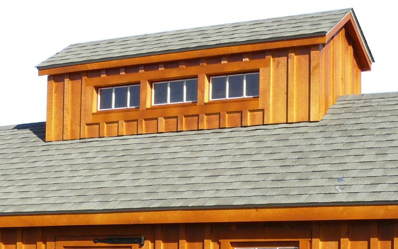 Pagoda roof on a shed with natural stained siding and gray roofing
