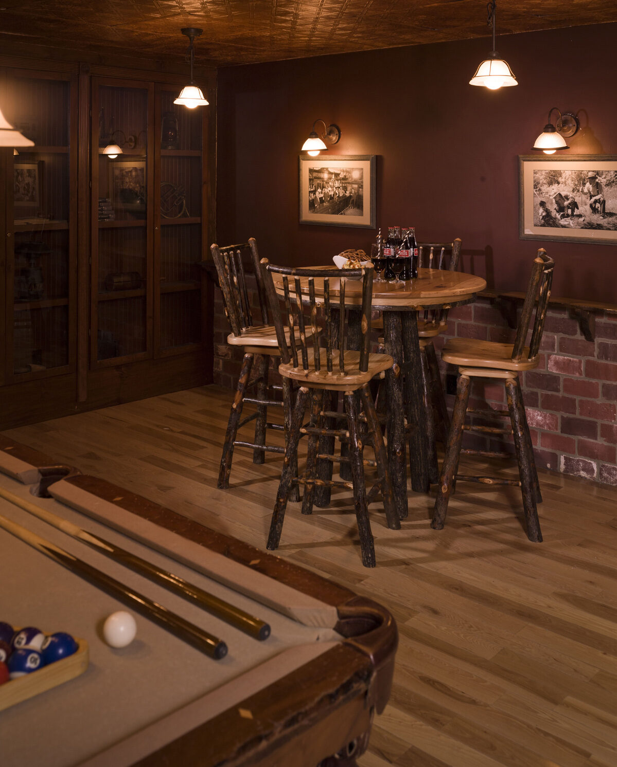 Hickory Collection Pub Table Set with 4 barstools and a round pub table beside a pool table