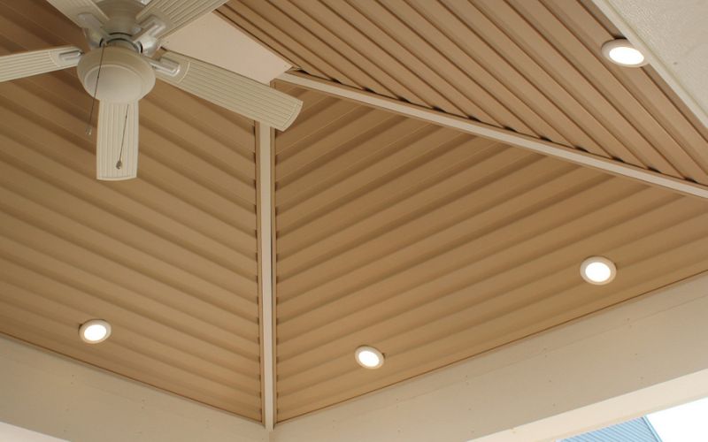 Close up of a finished shed ceiling with recessed lighting and a white ceiling fan