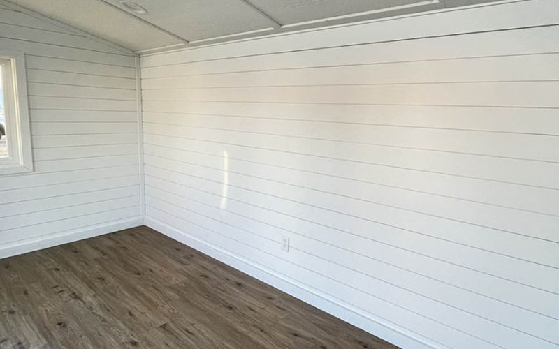 Shed interior with shiplap style shadow gap walls in white