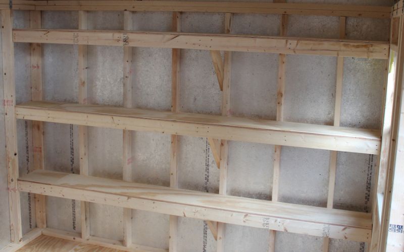 Close up of a shed wall with 3 large shelves