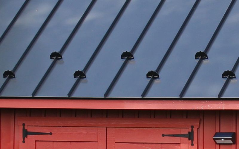 Close up of metal snow guards on a black metal roof