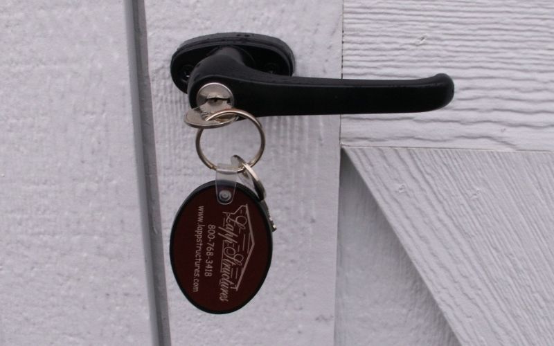 Close up of the outside view of a standard latch in black with a key inserted inside it