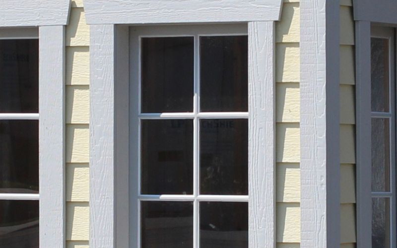 Close up of 6-pane vertical wood windows with light gray wood trim
