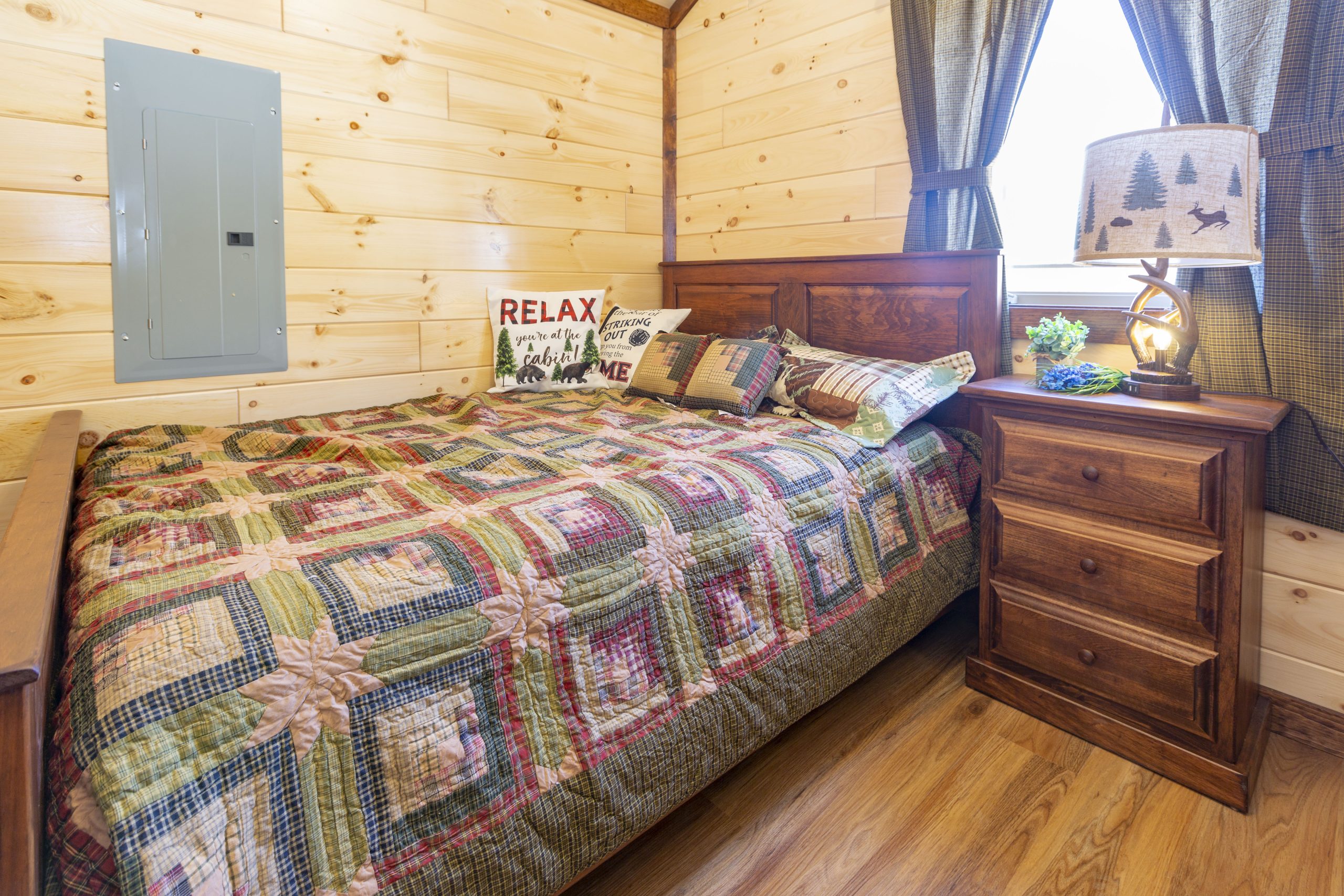 Photo of a bedroom in an Appalachian Park Model with rustic decor and natural wood walls.