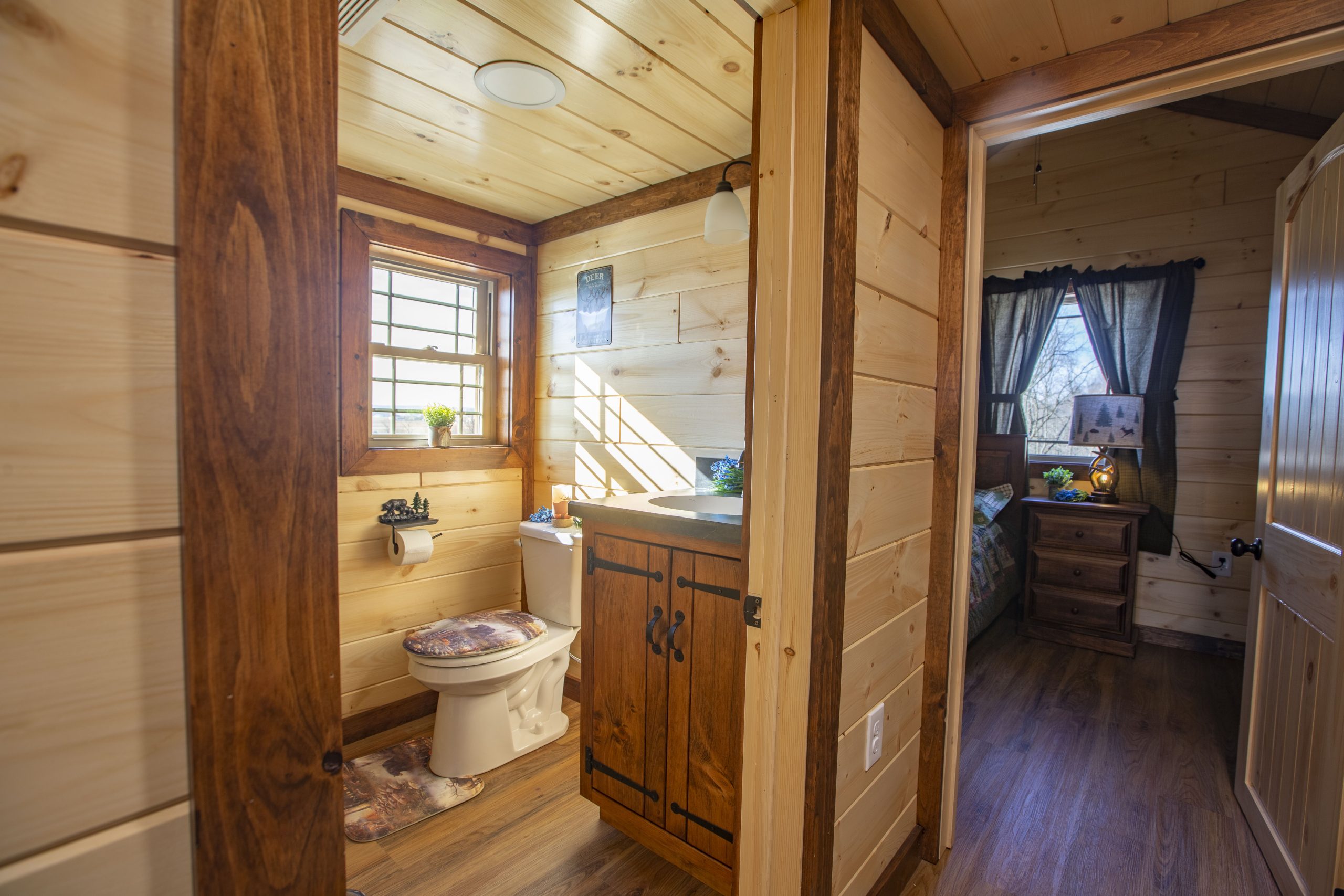 Hallway view of an Appalachian Park Model with open doors leading to a bathroom and a bedroom.