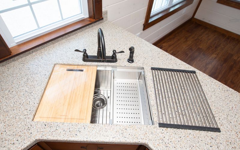 Removable kitchen sink multi-purpose compartments with a cutting board and 2 dish draining accessories.