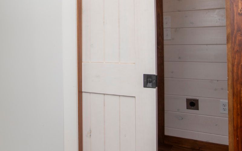 White wood pocket door with a black handle.