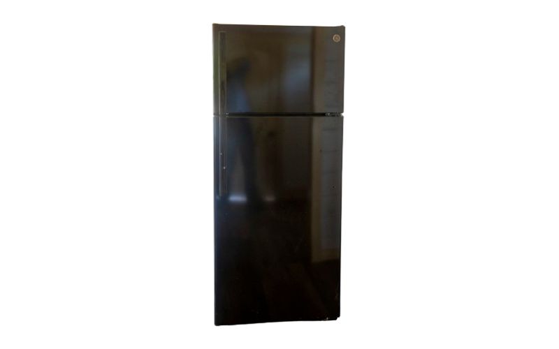 Black fridge with a freezer on top.