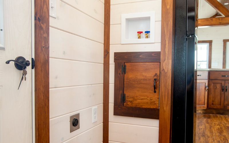 Close up of a washer and dryer hook up inside a park model entrance.