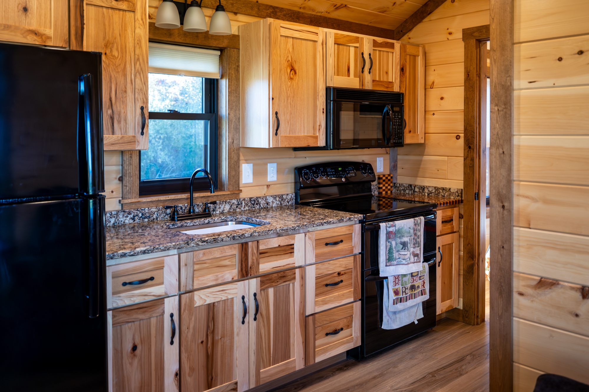kitchen with microwave, stove, sink, and fridge