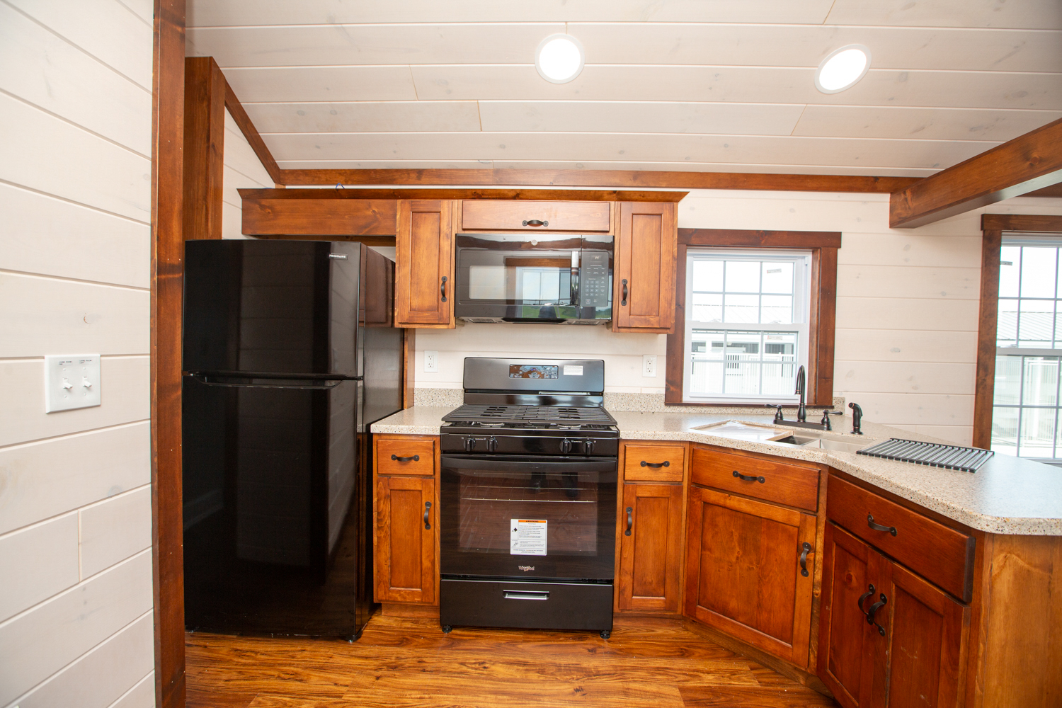 kitchen with fridge, stove, microwave, and sink in park model